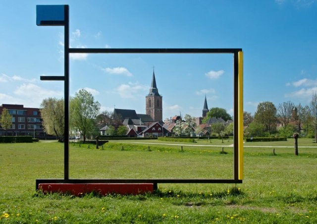 Het Mondriaan-kunstwerk in het park in Winterswijk, met de kerktoren op de achtergrond